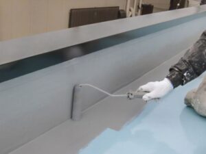 バルコニーの床面をグレーの防水材で塗り固めている様子